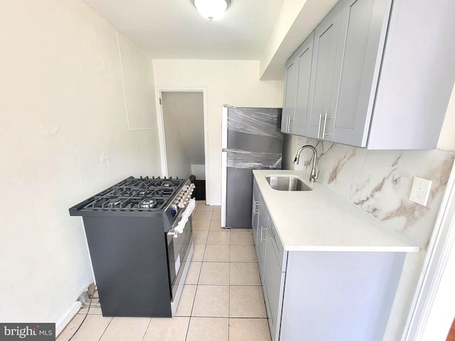 7107 Oakland St, Philadelphia, PA 19149 - kitchen featuring decorative backsplash, light tile patterned floors, stainless steel appliances, light countertops, and a sink