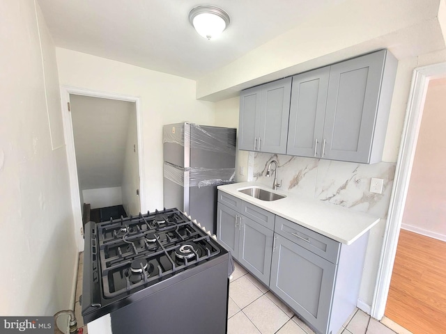 7107 Oakland St, Philadelphia, PA 19149 - kitchen with decorative backsplash, a sink, gray cabinetry, gas range oven, and light countertops