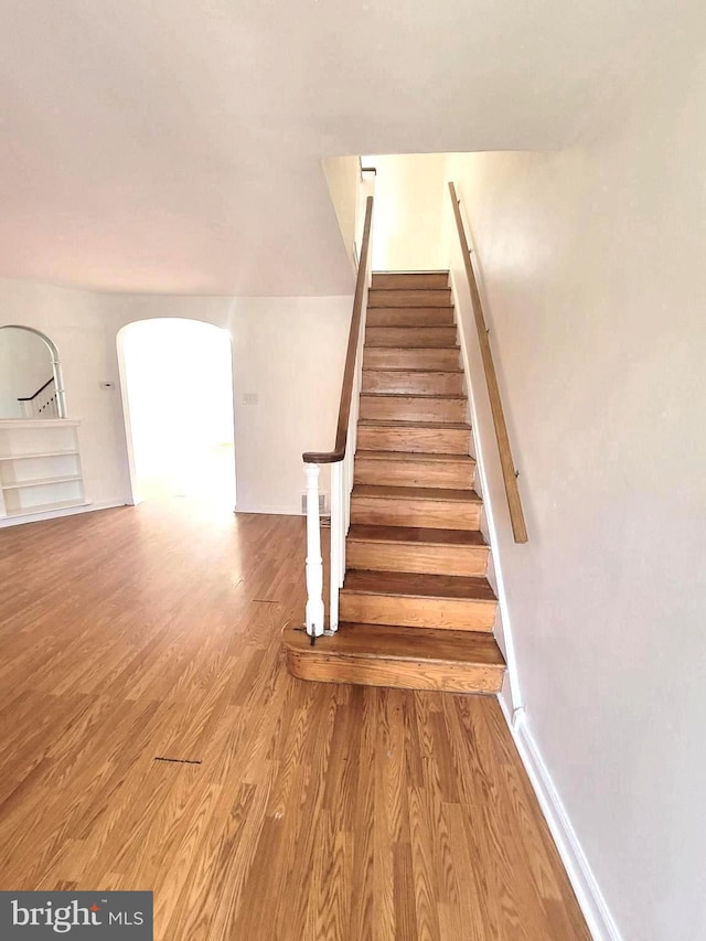 7107 Oakland St, Philadelphia, PA 19149 - stairs featuring wood finished floors, baseboards, and arched walkways