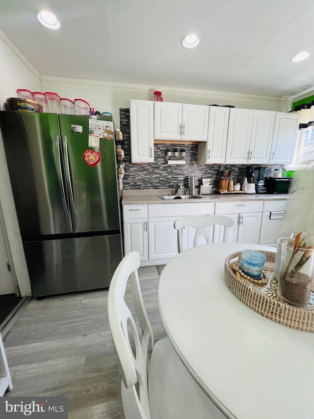 5625 Loretto Ave, Philadelphia, PA 19124 - kitchen featuring tasteful backsplash, light countertops, white cabinets, freestanding refrigerator, and recessed lighting