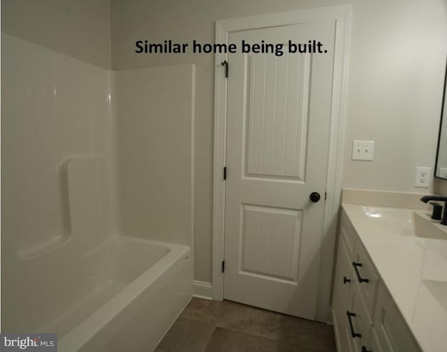 bathroom with shower / bathing tub combination, tile patterned flooring, double vanity, and a sink