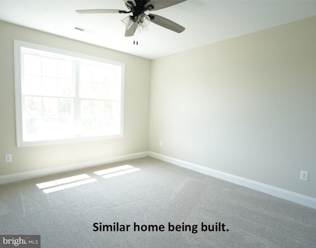 carpeted empty room featuring a ceiling fan, visible vents, and baseboards