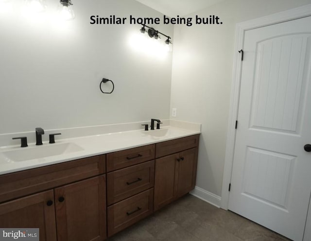 full bathroom with double vanity, a sink, and baseboards