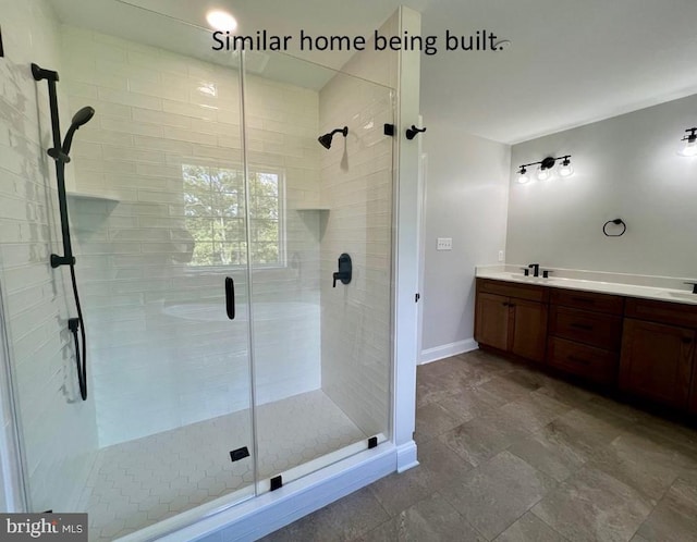 full bath with a stall shower, vanity, and baseboards