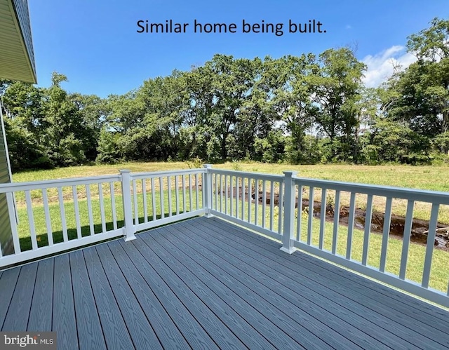 wooden terrace featuring a yard