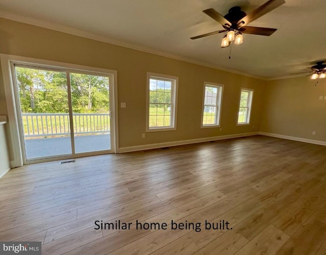 empty room featuring hardwood / wood-style floors, baseboards, ornamental molding, and a ceiling fan