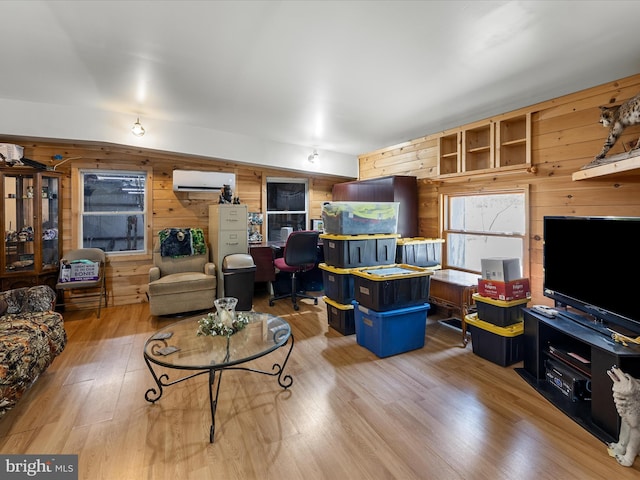 living area featuring a wall mounted air conditioner, wood walls, and wood finished floors