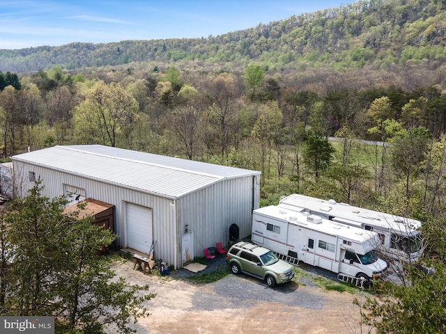 exterior space featuring an outdoor structure and a view of trees