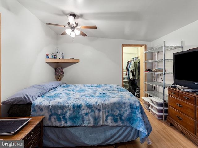 bedroom featuring a ceiling fan, a spacious closet, and light wood-type flooring