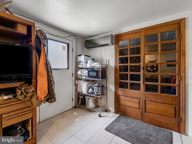 interior space featuring light tile patterned floors and an AC wall unit
