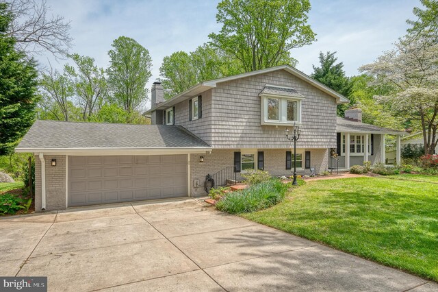 split level home featuring brick siding, a garage, a chimney, and concrete driveway