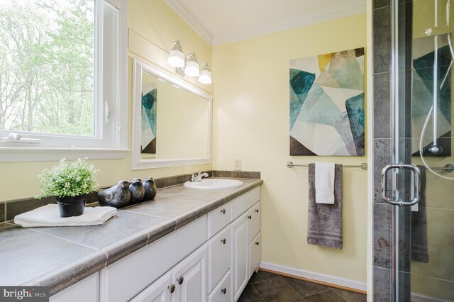 full bathroom featuring crown molding, a stall shower, baseboards, and vanity