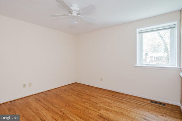 unfurnished room with light wood-style floors, a ceiling fan, baseboards, and visible vents