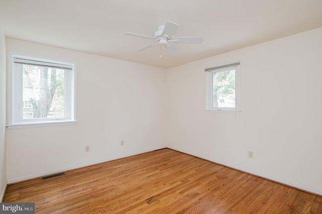 unfurnished room with visible vents, a ceiling fan, baseboards, and light wood-type flooring