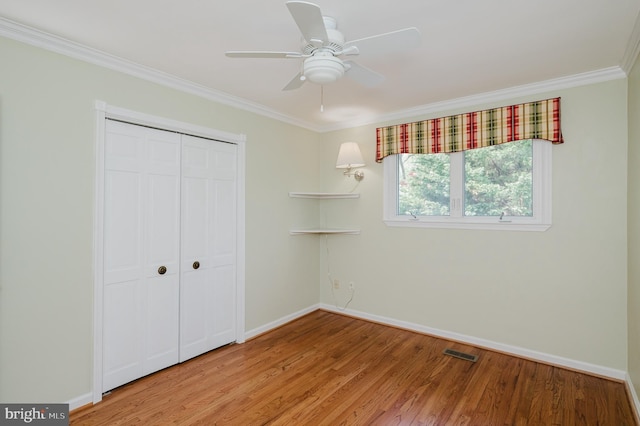 unfurnished bedroom with baseboards, ornamental molding, light wood finished floors, and visible vents