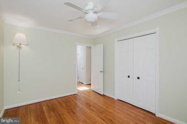 unfurnished bedroom with crown molding, baseboards, a closet, and light wood-type flooring