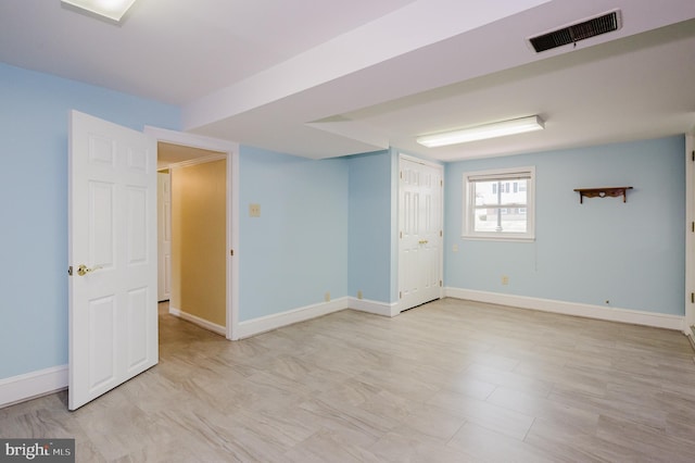 basement featuring baseboards and visible vents