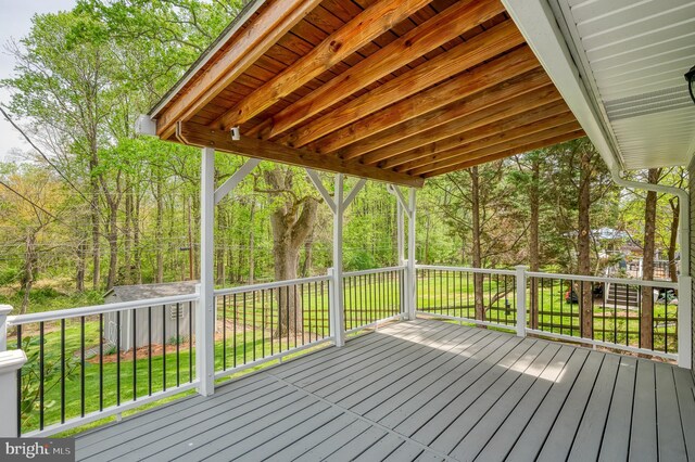 wooden deck featuring a lawn