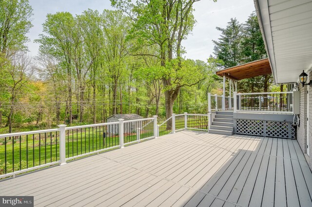 wooden terrace with a lawn, an outdoor structure, and a shed