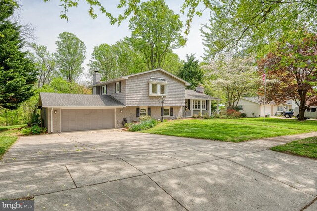 tri-level home featuring brick siding, a garage, driveway, and a chimney