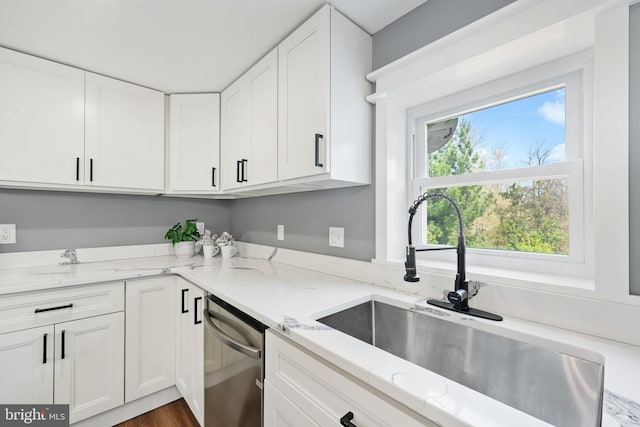 kitchen featuring white cabinetry, dishwasher, and a sink