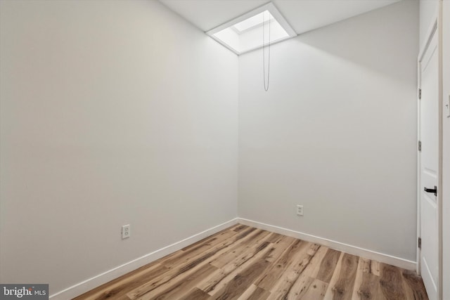 walk in closet featuring light wood finished floors and a skylight
