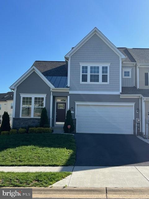 view of front facade featuring a front yard, driveway, and an attached garage
