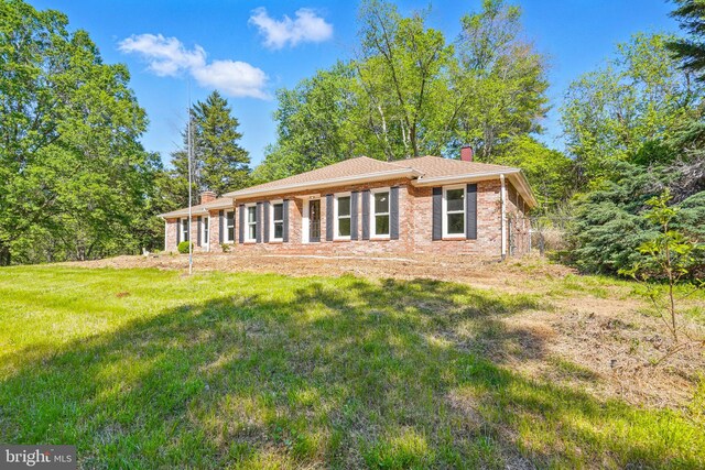 6611 Jupiter Dr, Huntingtown, MD 20639 - view of front facade with a chimney, a front lawn, and brick siding