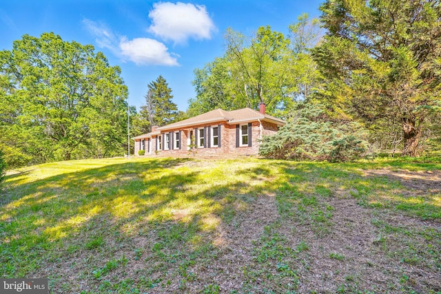 6611 Jupiter Dr, Huntingtown, MD 20639 - rear view of property with a lawn, a chimney, and brick siding