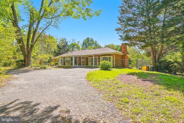 6611 Jupiter Dr, Huntingtown, MD 20639 - ranch-style house featuring fence, gravel driveway, french doors, a chimney, and brick siding