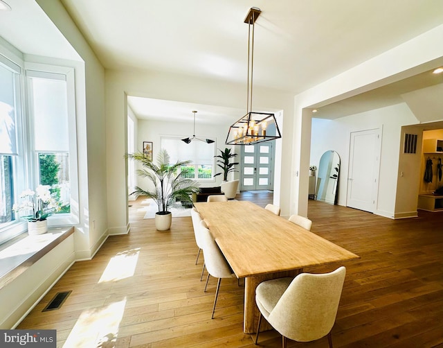 dining room featuring light wood finished floors, visible vents, and baseboards