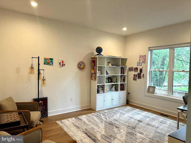 sitting room featuring baseboards, visible vents, wood finished floors, and recessed lighting