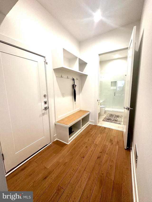 mudroom with wood-type flooring and baseboards