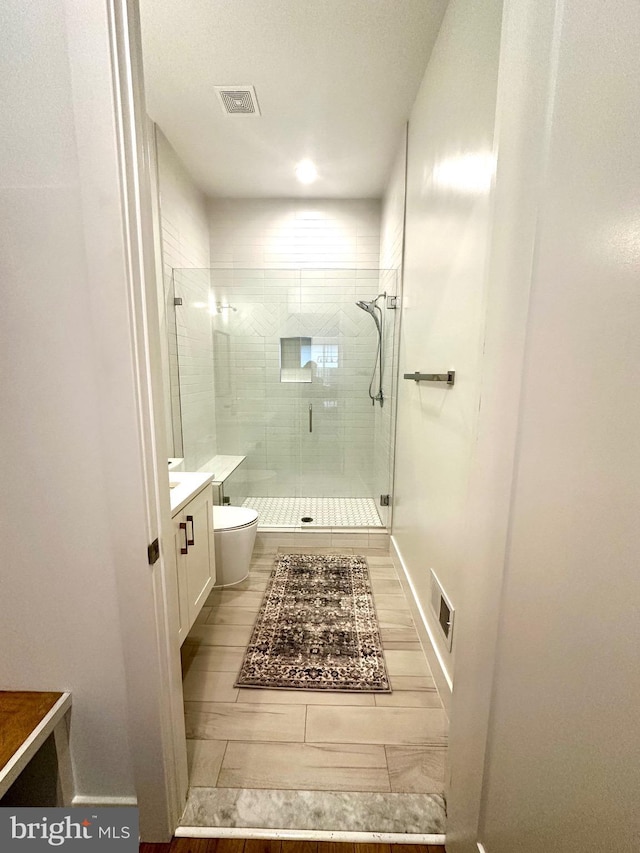 full bathroom with visible vents, toilet, a shower stall, and vanity