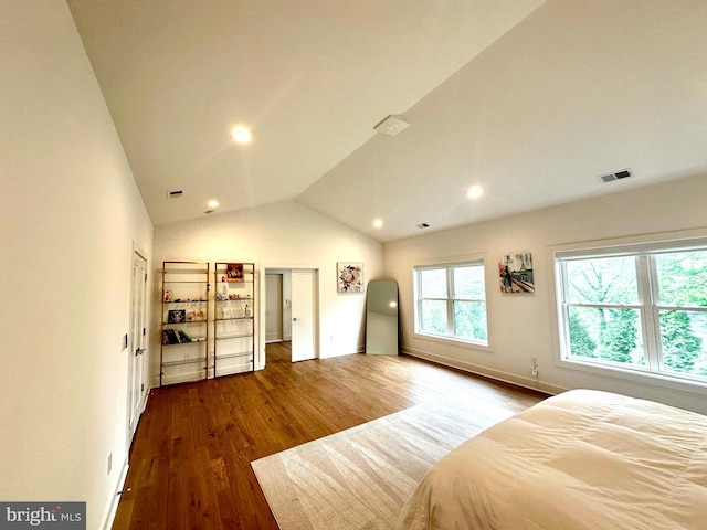 bedroom featuring lofted ceiling, visible vents, wood finished floors, and baseboards