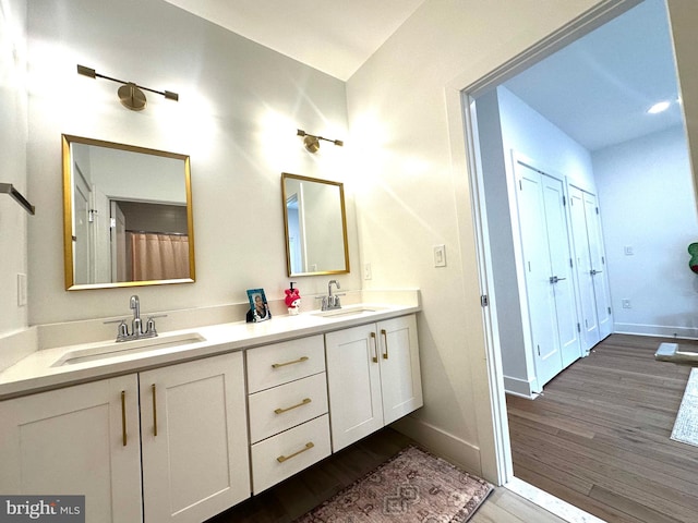 full bathroom with a sink, wood finished floors, and baseboards
