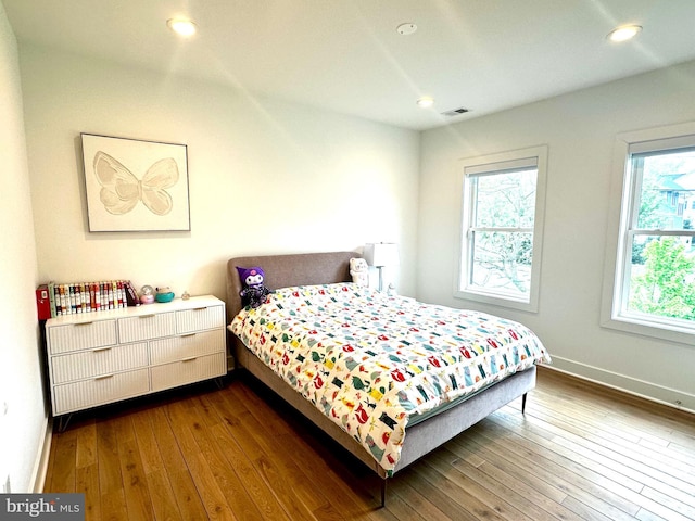 bedroom featuring visible vents, multiple windows, baseboards, and dark wood finished floors