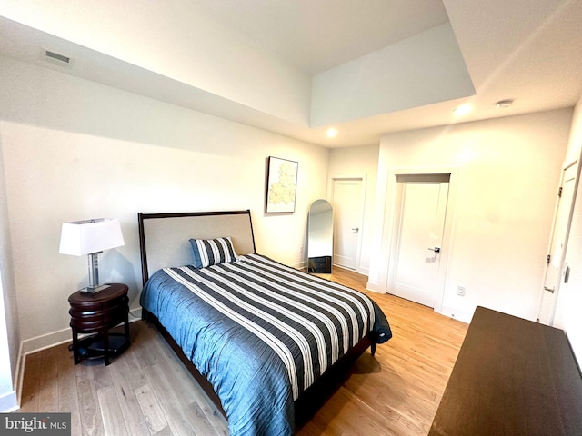 bedroom with recessed lighting, wood finished floors, and baseboards