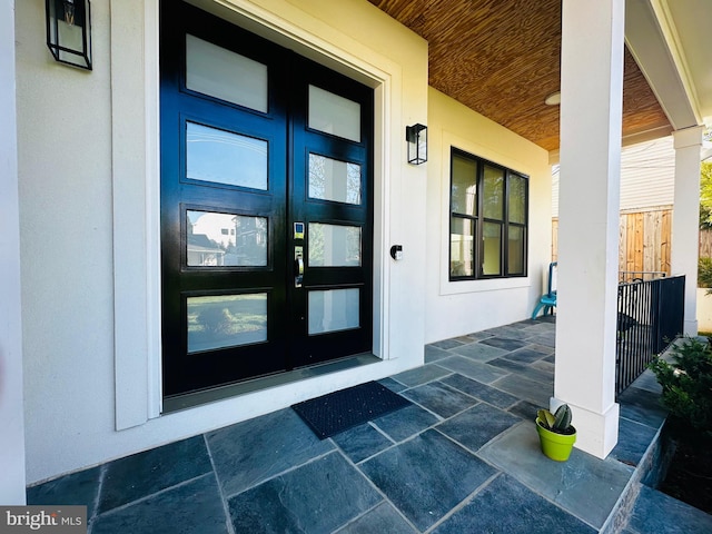 doorway to property featuring covered porch and french doors