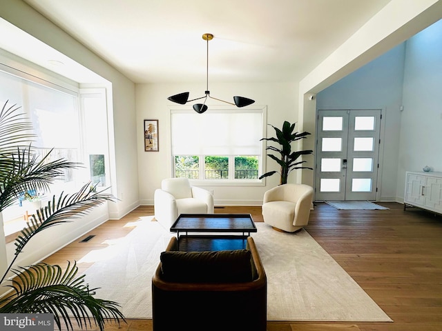 living area featuring baseboards, visible vents, and wood finished floors