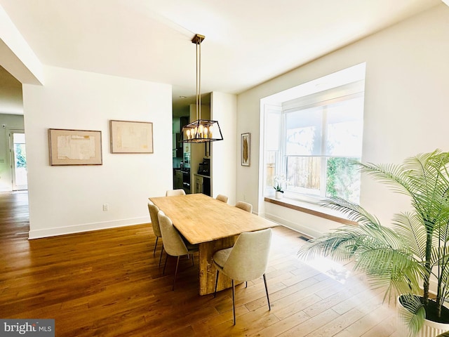 dining area featuring a chandelier, baseboards, visible vents, and wood-type flooring