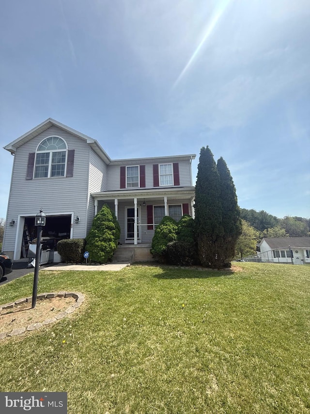 traditional home featuring a garage, covered porch, and a front lawn