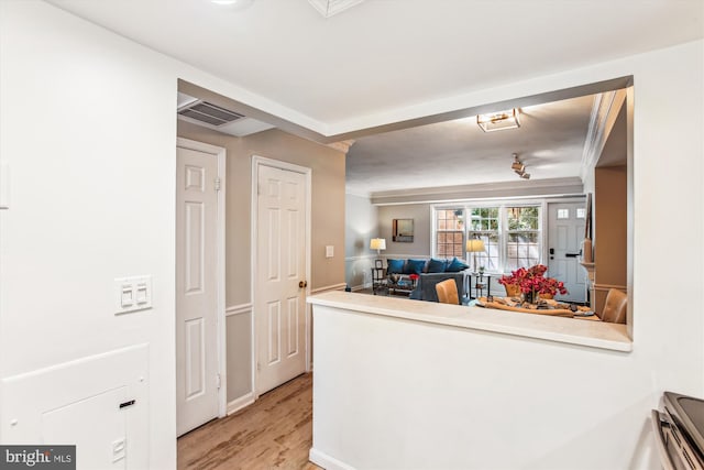 interior space with visible vents, a peninsula, light wood-style floors, open floor plan, and light countertops