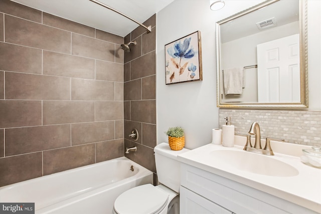 bathroom featuring visible vents, vanity, toilet, shower / bathing tub combination, and tasteful backsplash