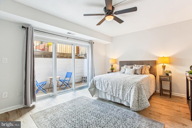 bedroom with baseboards, visible vents, access to exterior, and wood finished floors