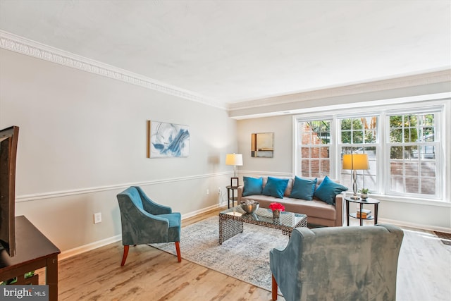 living room featuring crown molding, baseboards, and wood finished floors