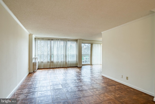 unfurnished room with baseboards, ornamental molding, and a textured ceiling