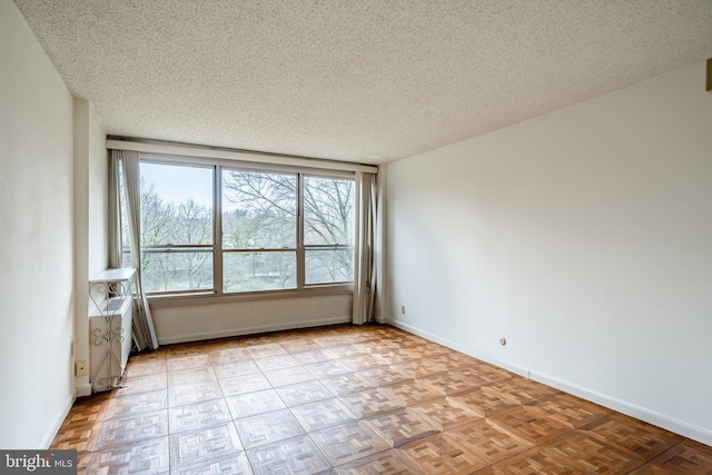 unfurnished room featuring baseboards and a textured ceiling