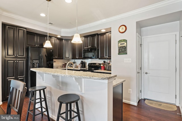 kitchen featuring dark wood-style flooring, visible vents, a kitchen breakfast bar, and black appliances