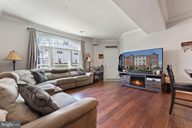 living area featuring ornamental molding, a lit fireplace, wood finished floors, and visible vents